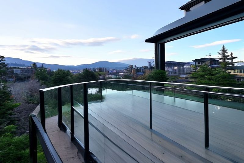 Modern frameless glass deck railing with stainless steel spigots — North Vancouver condo balcony